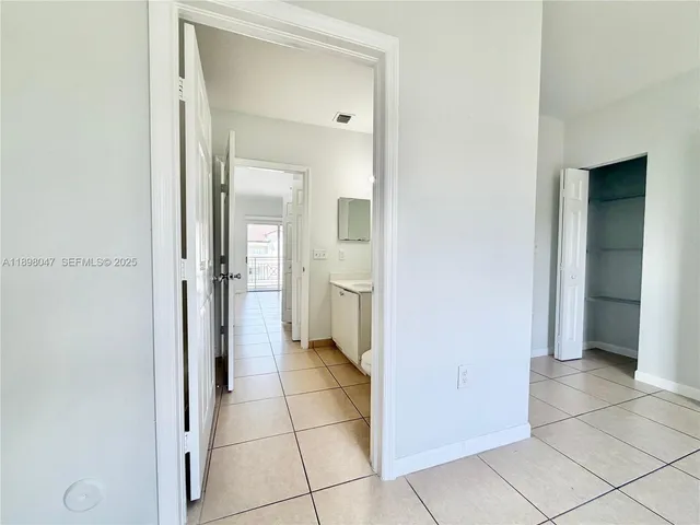 a view of a hallway with a room and a bathroom