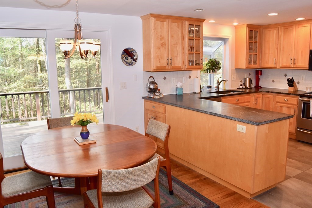 227 Heatherstone Road Amherst, MA 01002 - Photo 11 of 42 a kitchen with a sink a window and dining table in it