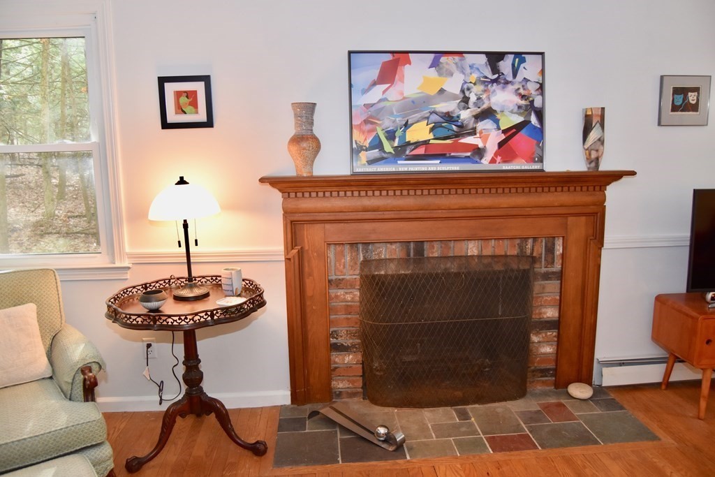 227 Heatherstone Road Amherst, MA 01002 - Photo 6 of 42 a living room with a fireplace and a painting on the wall