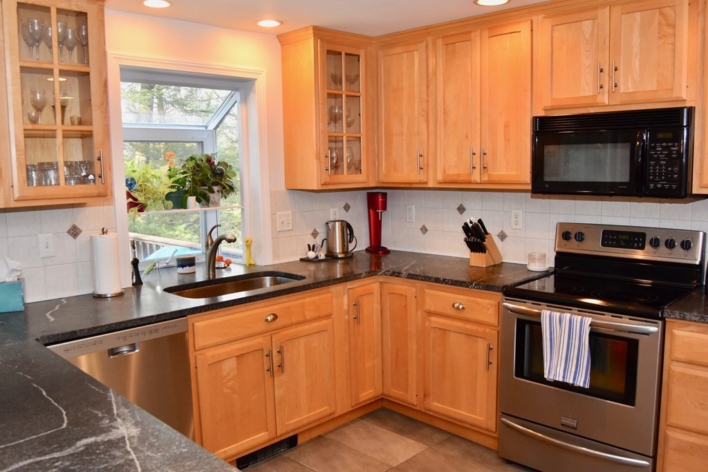 227 Heatherstone Road Amherst, MA 01002 - Photo 9 of 42 a kitchen with stainless steel appliances granite countertop a sink stove and microwave