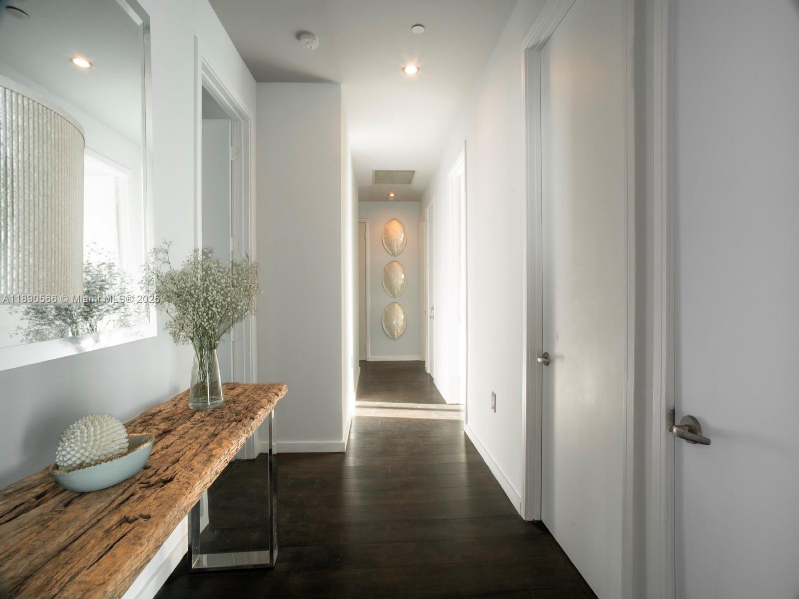 900 Brickell Key Boulevard, Unit 2204 Miami, FL 33131 - Photo 11 of 40 a view of a hallway with furniture and wooden floor