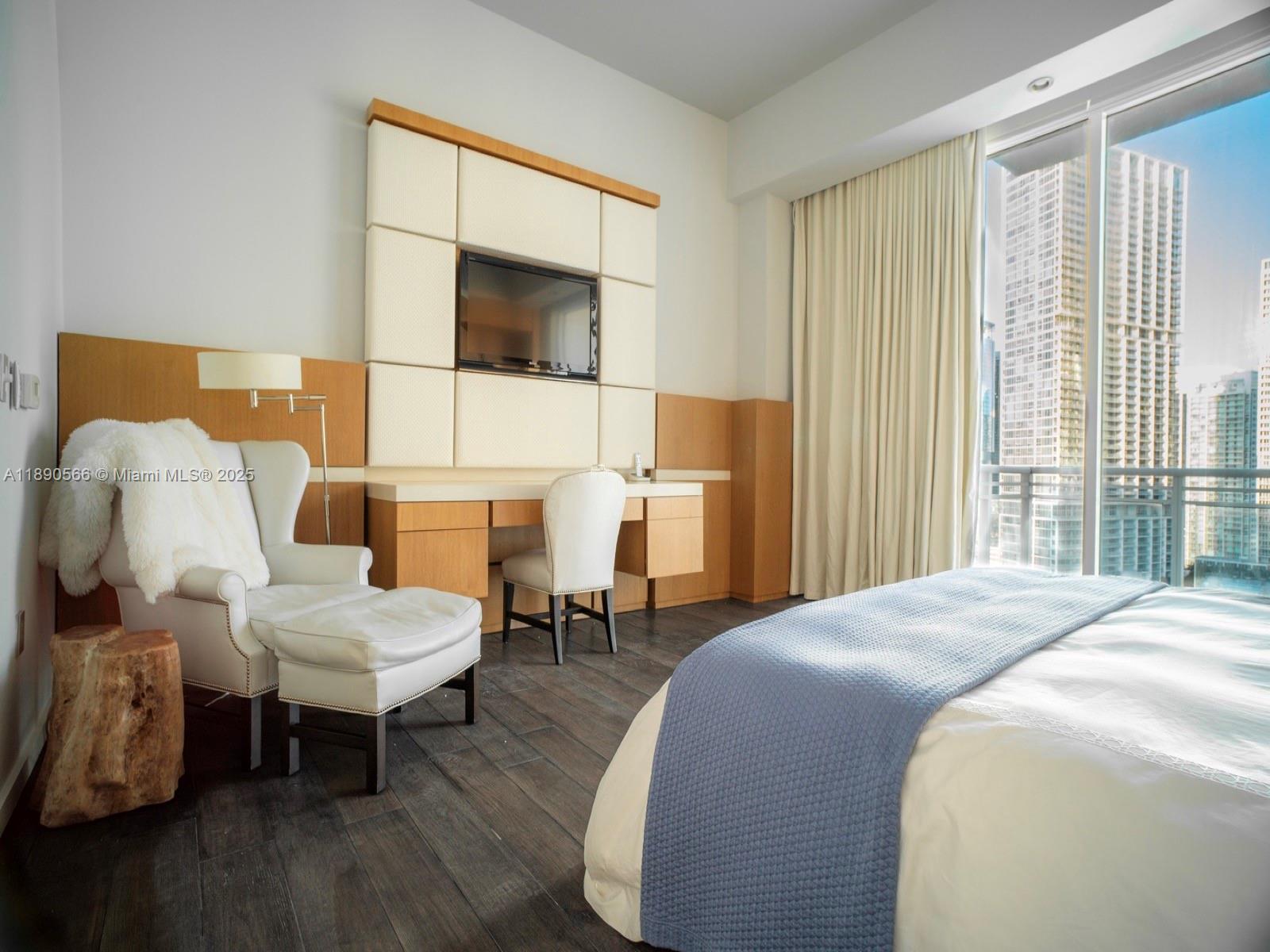 900 Brickell Key Boulevard, Unit 2204 Miami, FL 33131 - Photo 12 of 40 a spacious bedroom with a bed and a couch