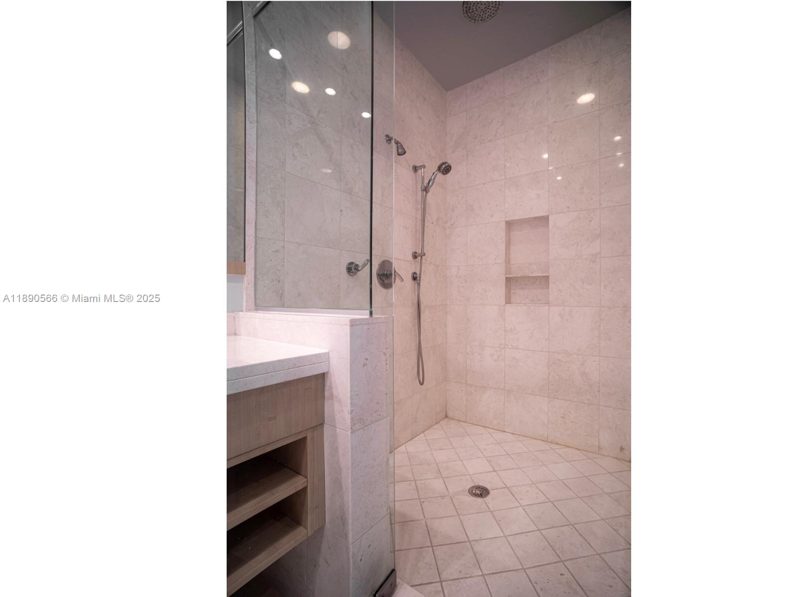 900 Brickell Key Boulevard, Unit 2204 Miami, FL 33131 - Photo 16 of 40 a bathroom with a sink a toilet a shower and a mirror