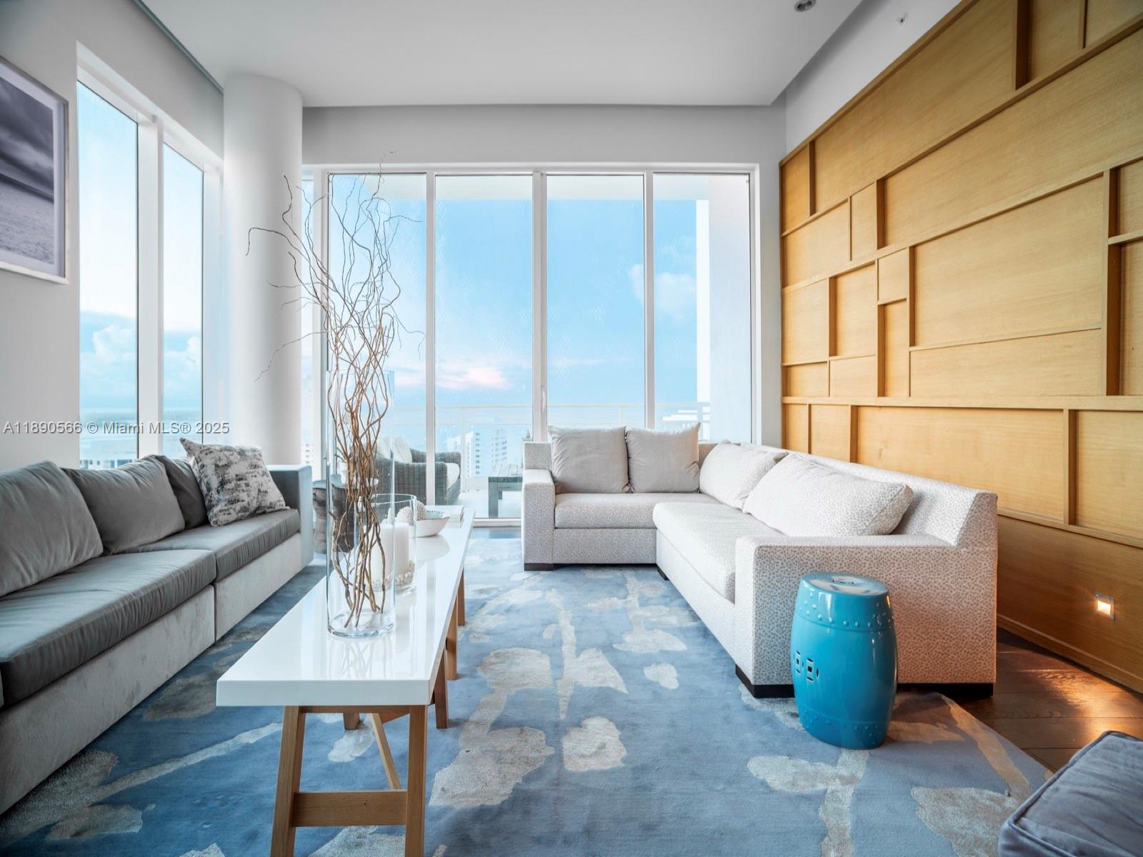 900 Brickell Key Boulevard, Unit 2204 Miami, FL 33131 - Photo 2 of 40 a living room with furniture and a large window