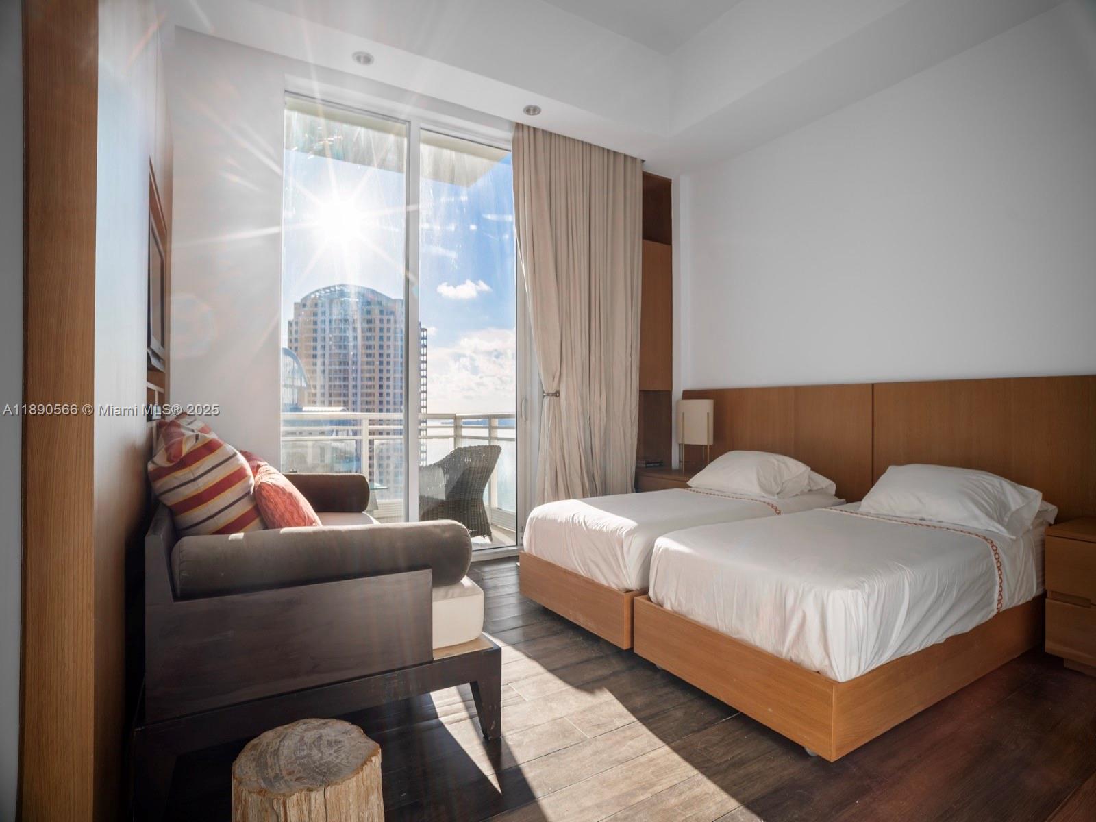 900 Brickell Key Boulevard, Unit 2204 Miami, FL 33131 - Photo 22 of 40 a bedroom with a bed and glass window