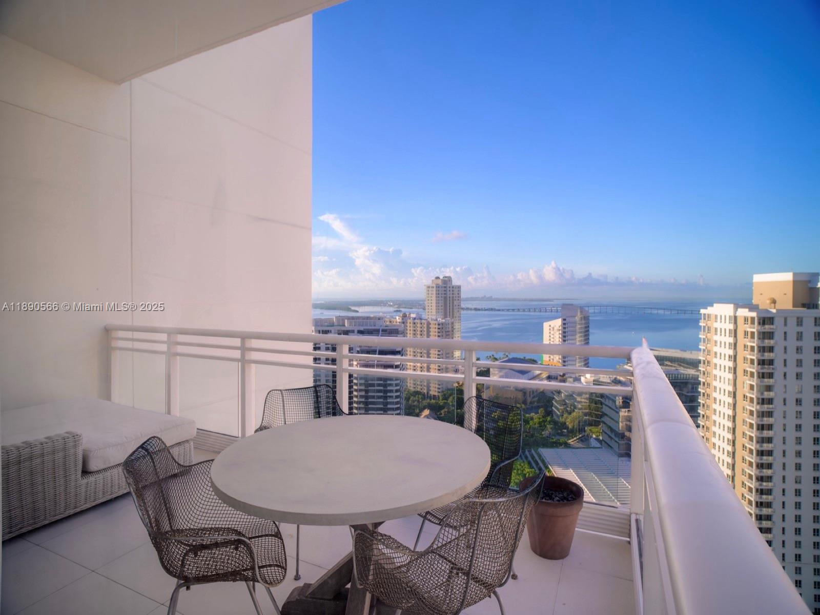900 Brickell Key Boulevard, Unit 2204 Miami, FL 33131 - Photo 9 of 40 a balcony with a table and chairs