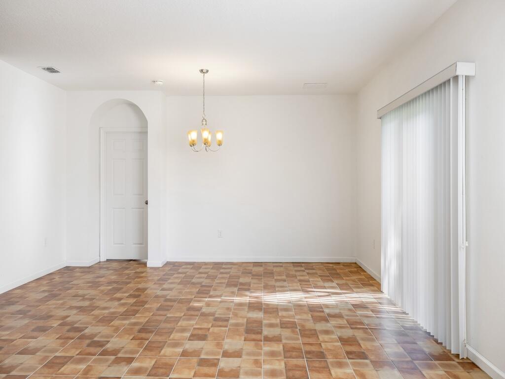 1440 Lexington Square Southwest Vero Beach, FL 32962 - Photo 15 of 41 a view of a room with wooden floor and ceiling fan