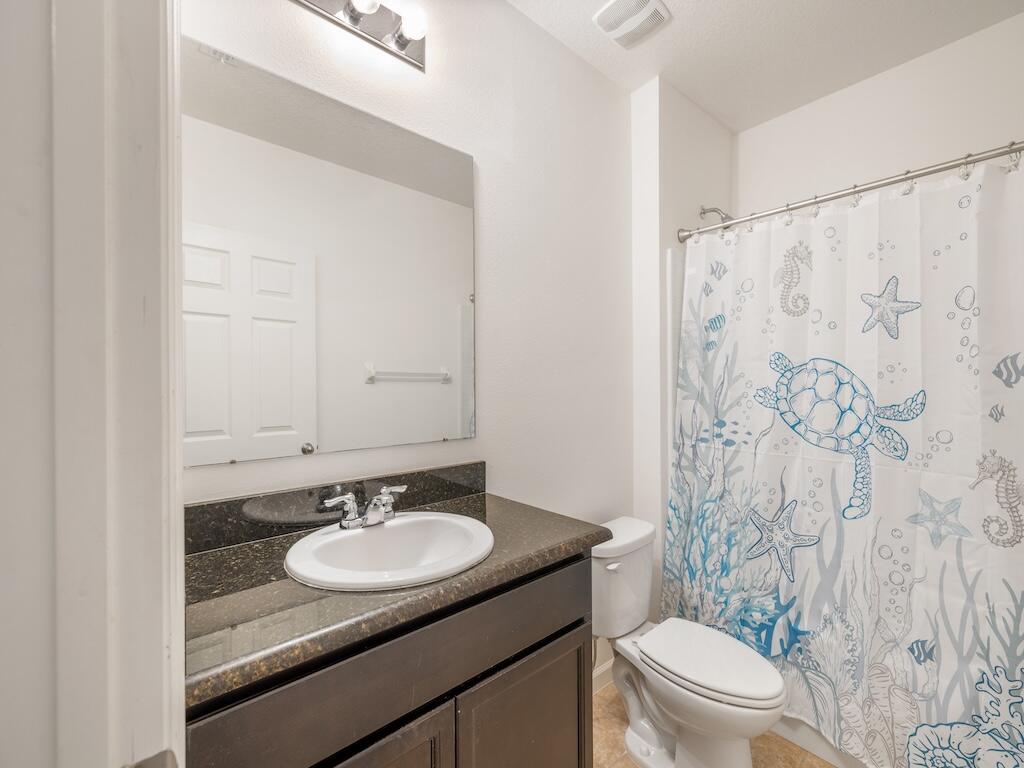 1440 Lexington Square Southwest Vero Beach, FL 32962 - Photo 18 of 41 a bathroom with a granite countertop sink toilet a mirror and shower curtain