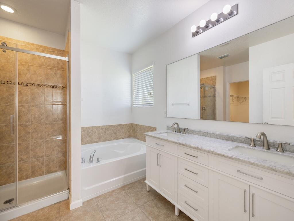 1440 Lexington Square Southwest Vero Beach, FL 32962 - Photo 31 of 41 a bathroom with a granite countertop sink a mirror a bathtub and next to a window