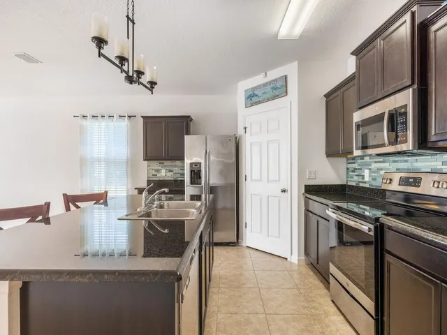 a kitchen with stainless steel appliances granite countertop a stove refrigerator and microwave