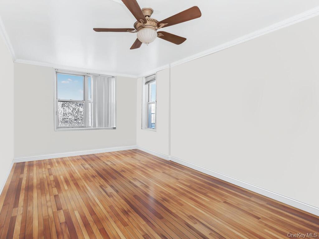 1475 Thieriot Avenue, Unit 5N Bronx, NY 10460 - Photo 11 of 22 an empty room with wooden floor ceiling fan and windows