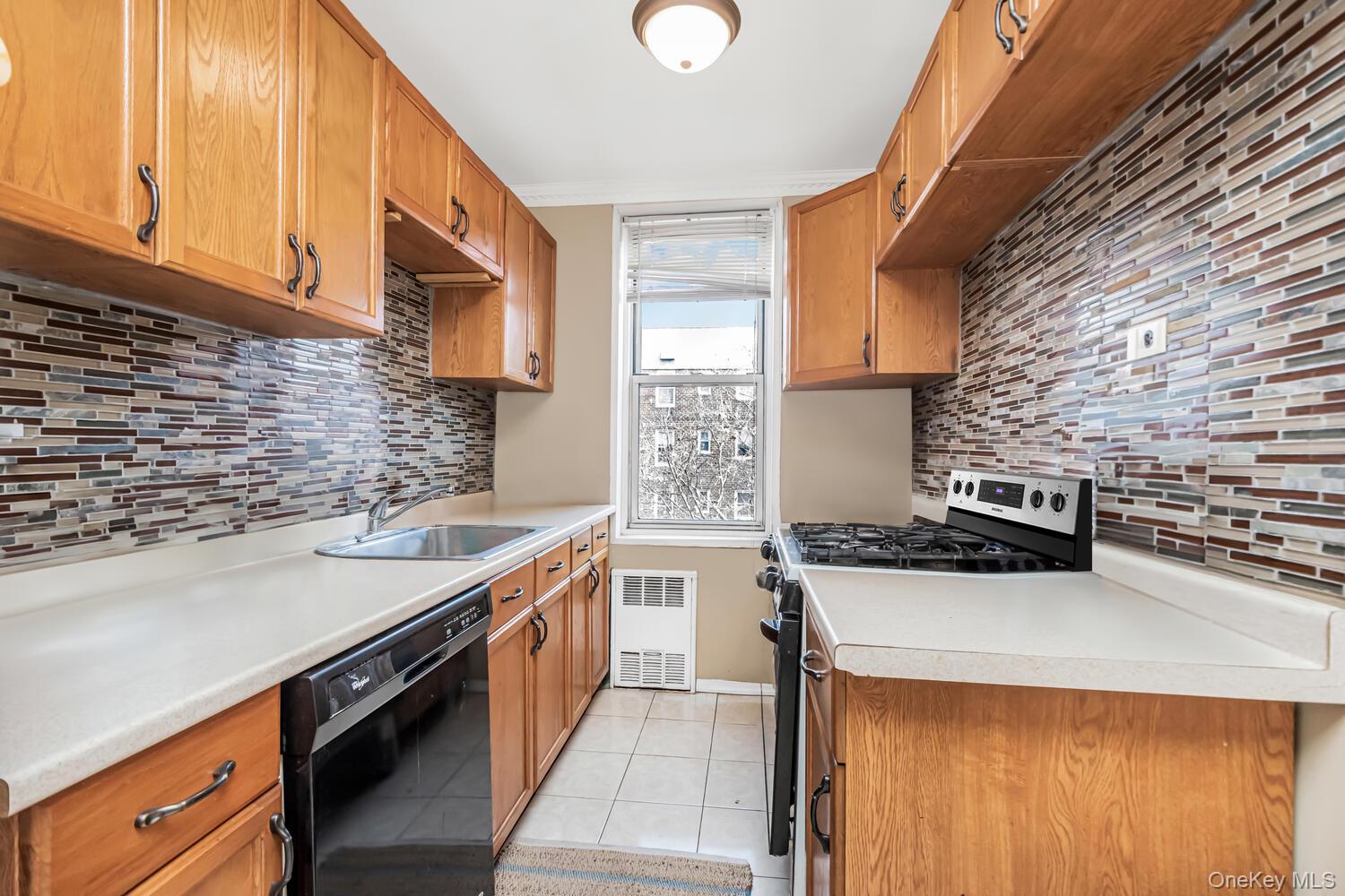 1475 Thieriot Avenue, Unit 5N Bronx, NY 10460 - Photo 8 of 22 a kitchen with stainless steel appliances granite countertop a stove a sink and a microwave