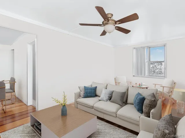 an empty room with wooden floor ceiling fan and windows