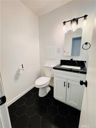a bathroom with a sink a toilet and a mirror