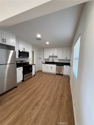 a large kitchen with stainless steel appliances granite countertop a refrigerator oven a stove top oven a sink and dishwasher