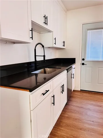 a kitchen with granite countertop a sink and cabinets