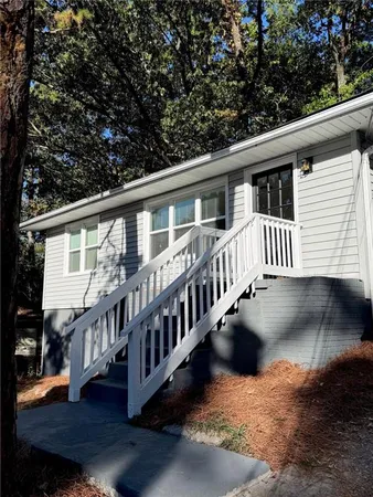 a view of a house with wooden deck front of house