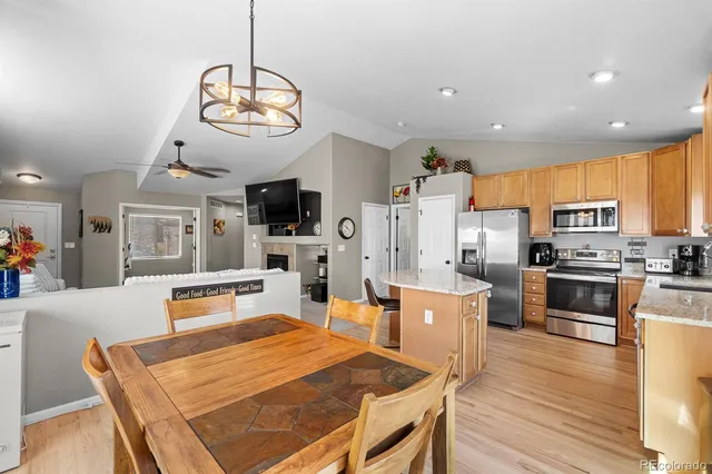 a living room with stainless steel appliances kitchen island granite countertop furniture and a wooden floor