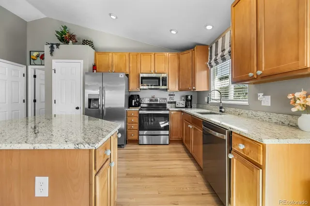 a kitchen with stainless steel appliances granite countertop a sink stove and refrigerator
