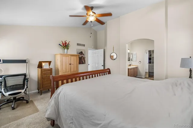 a bedroom with a bed wooden floor and a chandelier
