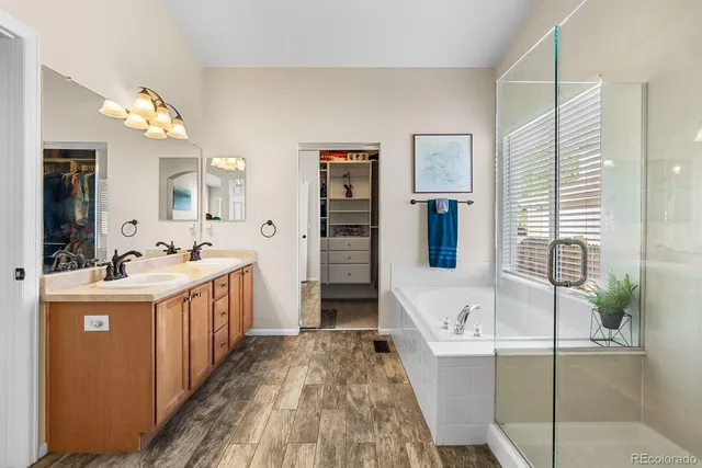 a bathroom with a tub sink and mirror