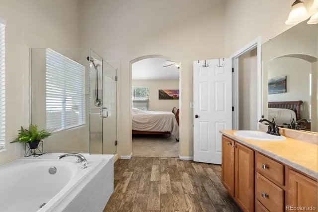 a en suite spacious bathroom with a tub double vanity and a mirror