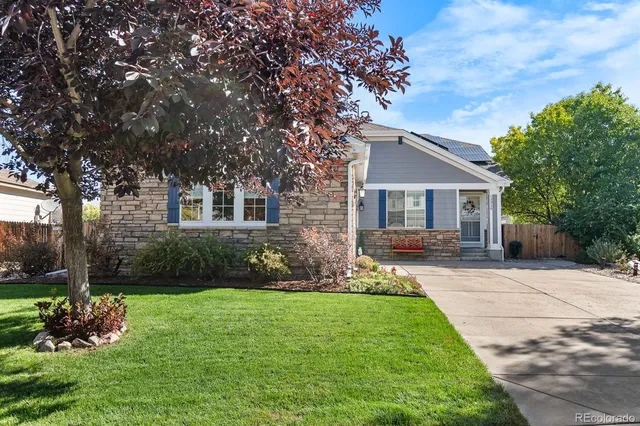a front view of a house with a garden and yard