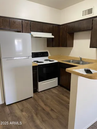 a kitchen with stainless steel appliances a stove a sink and a refrigerator