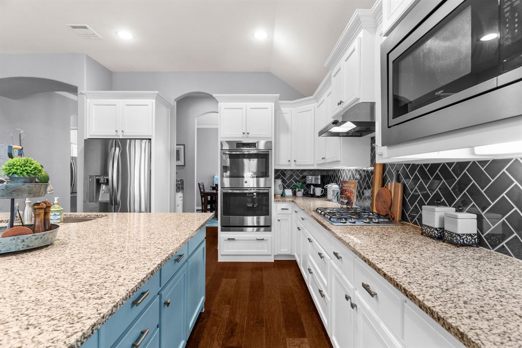 5604 Datewood Lane McKinney, TX 75071 - Photo 12 of 40 a large kitchen with stainless steel appliances kitchen island granite countertop a large counter top and wooden cabinets