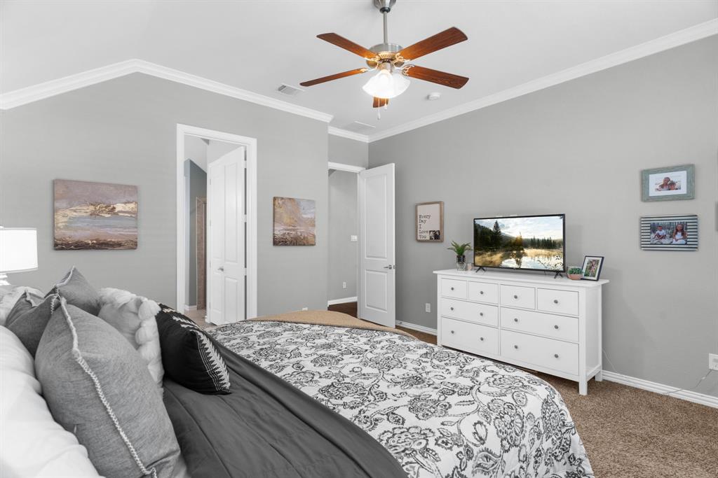 5604 Datewood Lane McKinney, TX 75071 - Photo 18 of 40 a bedroom with a bed and a dresser in it