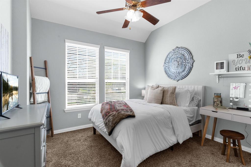 5604 Datewood Lane McKinney, TX 75071 - Photo 21 of 40 a bedroom with a bed a chandelier and a window
