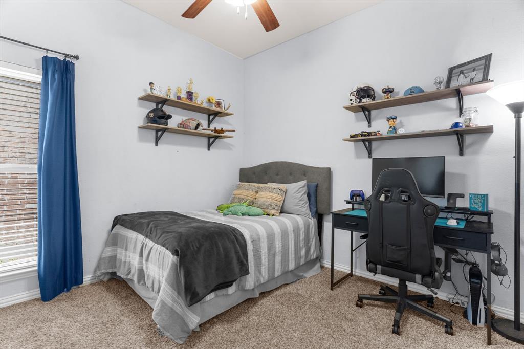 5604 Datewood Lane McKinney, TX 75071 - Photo 23 of 40 a bedroom with a bed and a chandelier