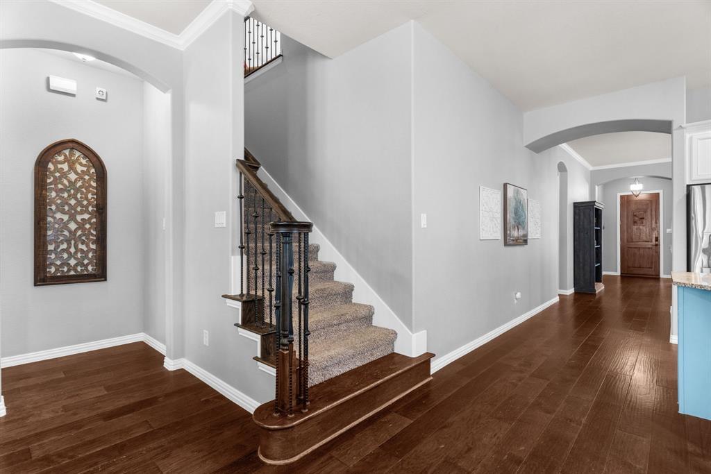 5604 Datewood Lane McKinney, TX 75071 - Photo 7 of 40 a view of a hallway with entryway wooden floor and front door