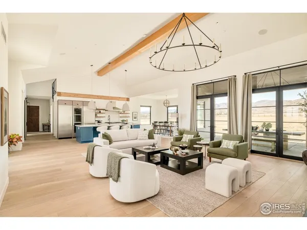 a living room with stainless steel appliances kitchen island granite countertop a table chairs and a view of living room