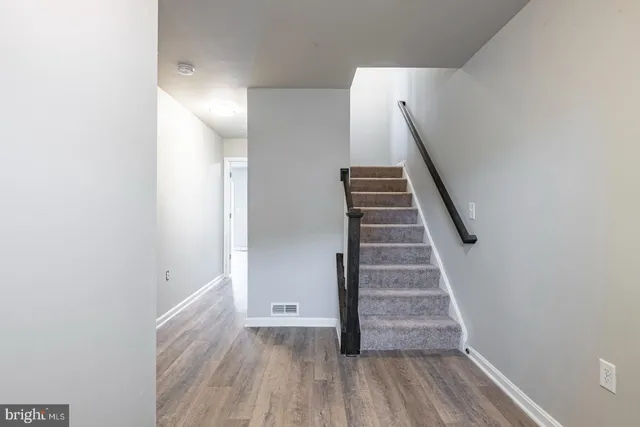 a view of a hallway with wooden floor and entryway
