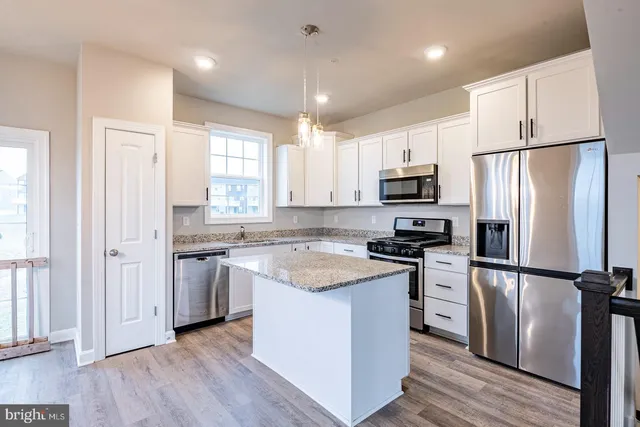 a kitchen with stainless steel appliances a refrigerator sink and microwave