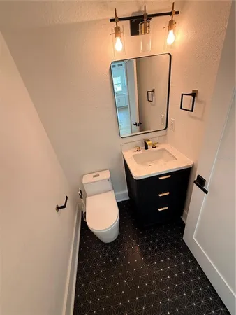 a bathroom with a sink toilet and mirror