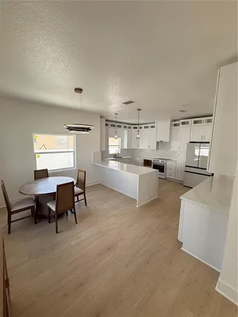 a living room with furniture and a dining table with kitchen view