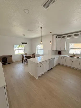 a large white kitchen with cabinets and a couch
