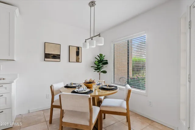 a kitchen with stainless steel appliances a white table and chairs in it