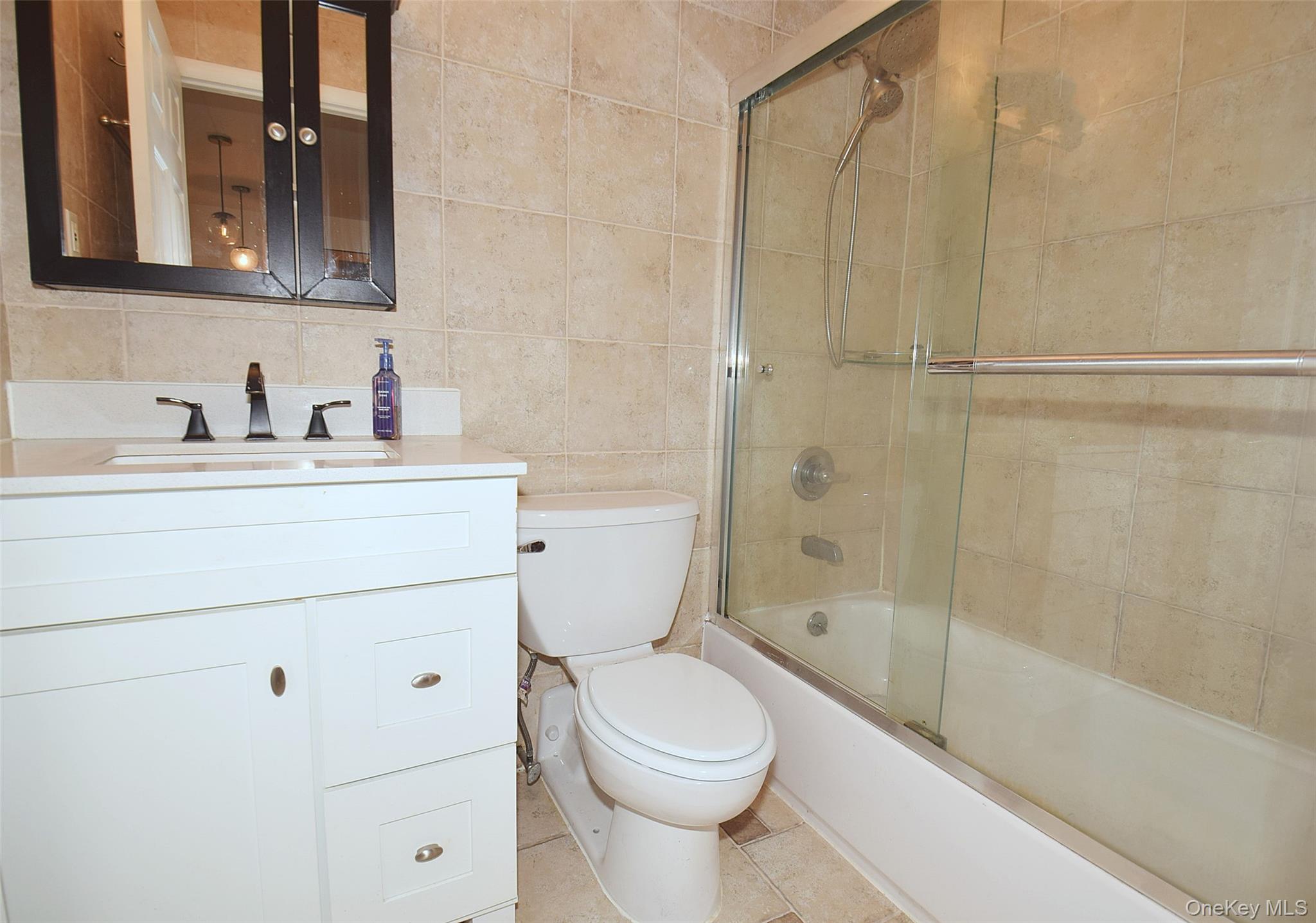 12-36 Estates Lane, Unit 49L Queens, NY 11360 - Photo 13 of 37 a bathroom with a sink a toilet and shower