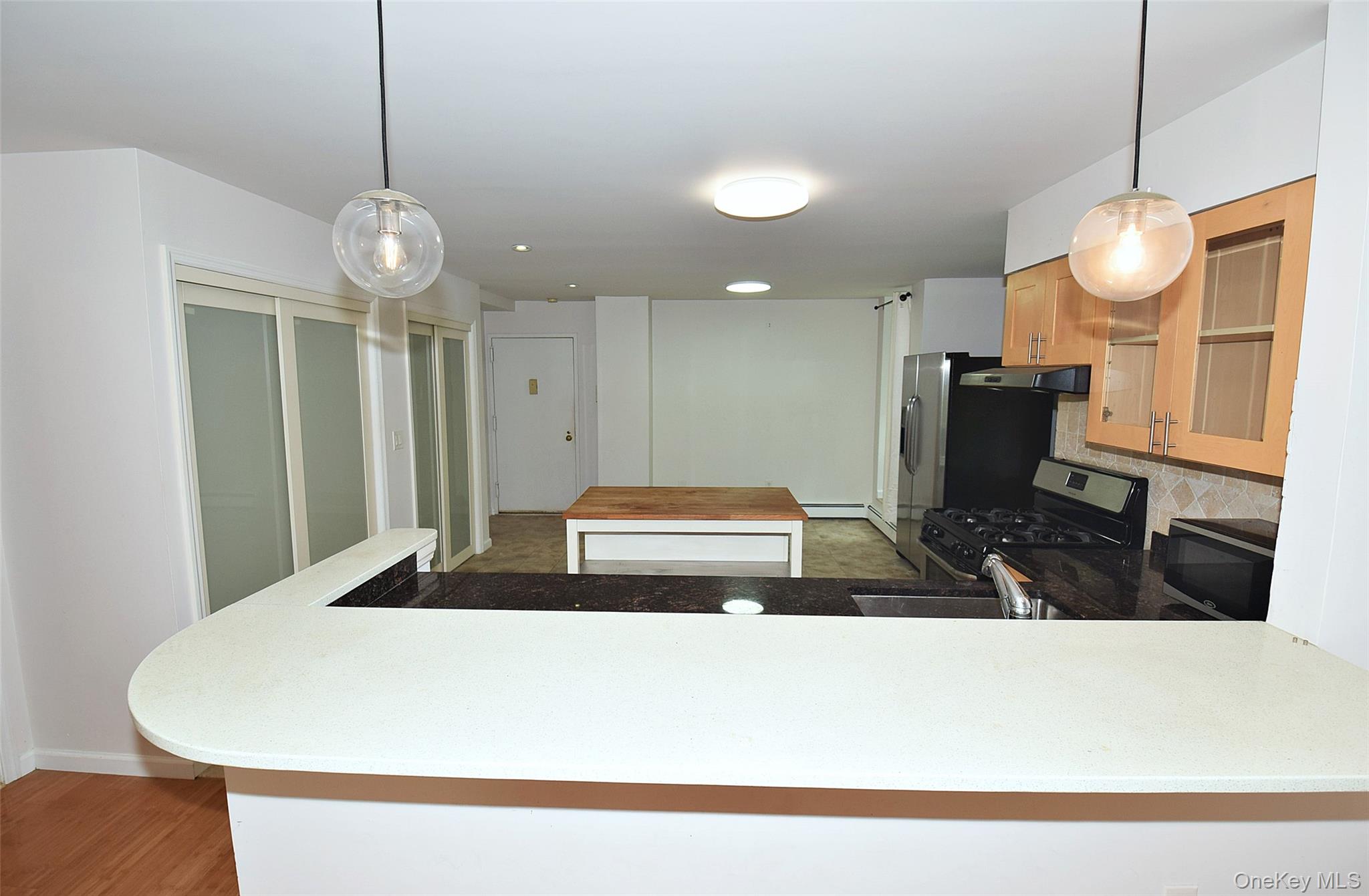 12-36 Estates Lane, Unit 49L Queens, NY 11360 - Photo 14 of 37 a kitchen with a table and chairs