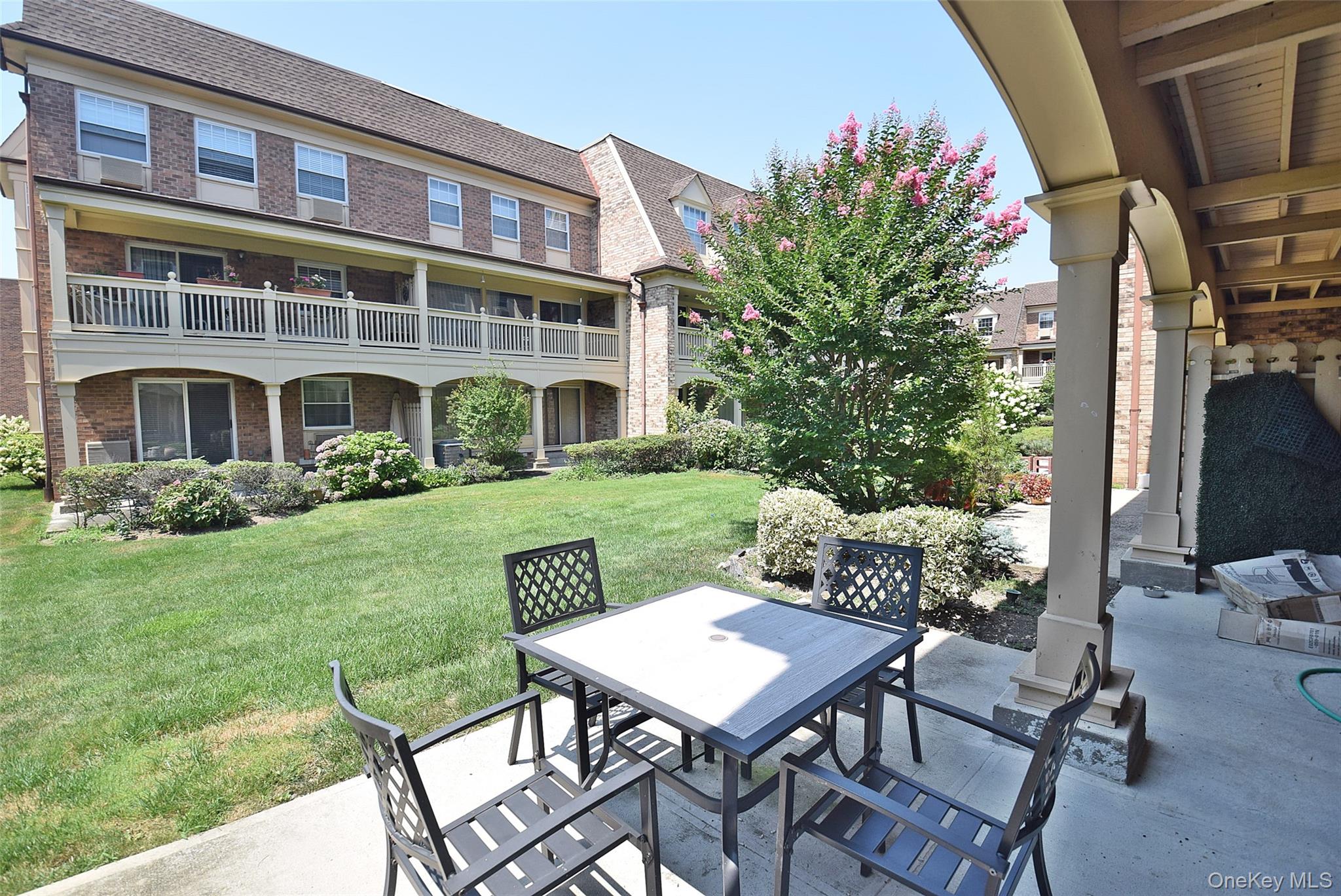 12-36 Estates Lane, Unit 49L Queens, NY 11360 - Photo 16 of 37 a view of a patio with table and chairs and potted plants