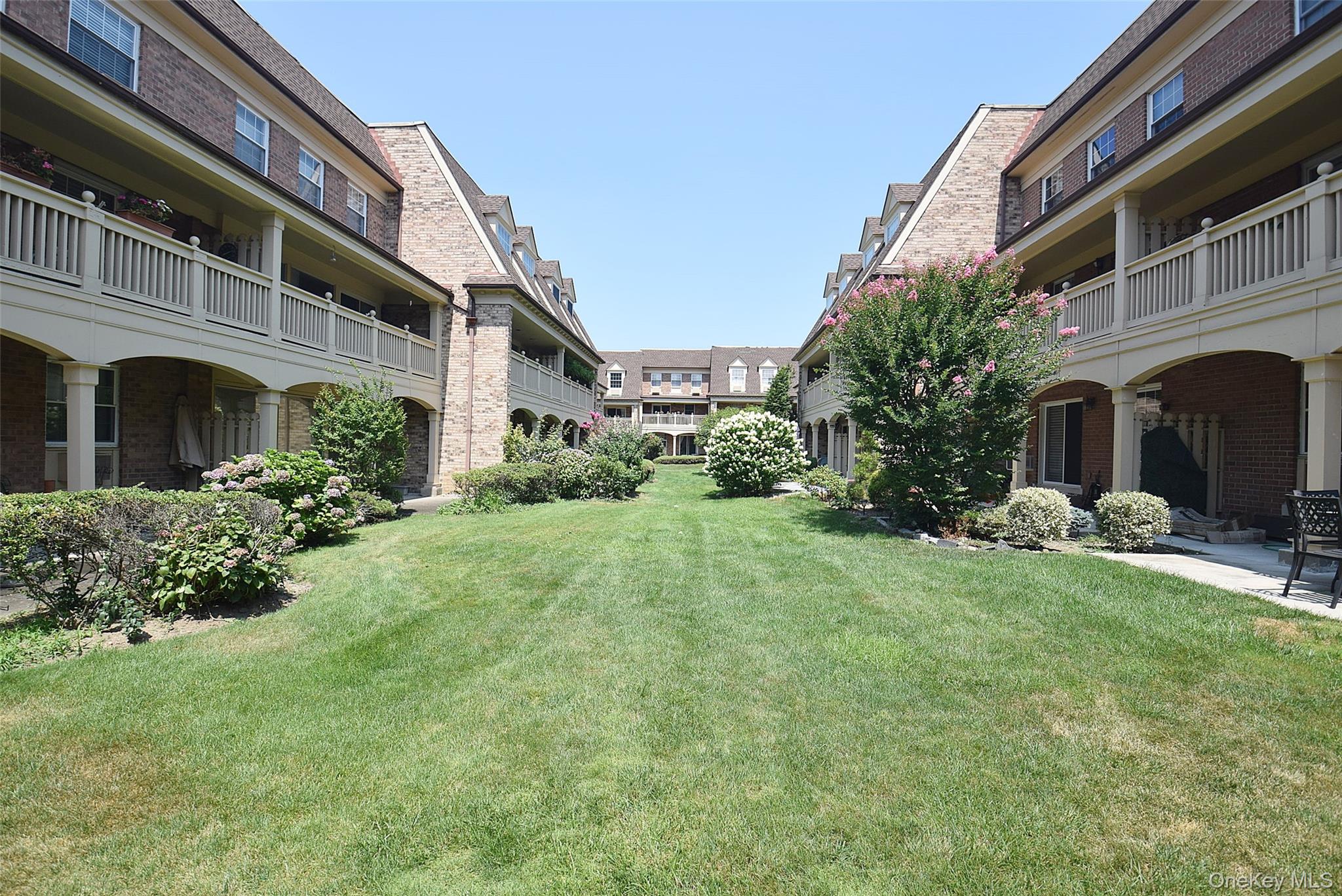 12-36 Estates Lane, Unit 49L Queens, NY 11360 - Photo 18 of 37 a view of a house with a garden