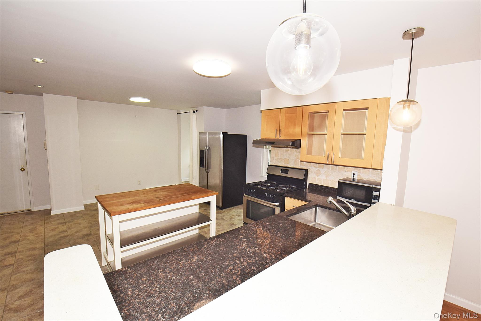 12-36 Estates Lane, Unit 49L Queens, NY 11360 - Photo 2 of 37 a living room with furniture a table and chairs