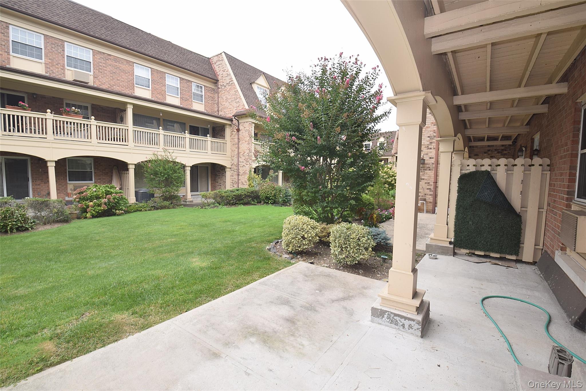 12-36 Estates Lane, Unit 49L Queens, NY 11360 - Photo 31 of 37 a front view of a house with garden