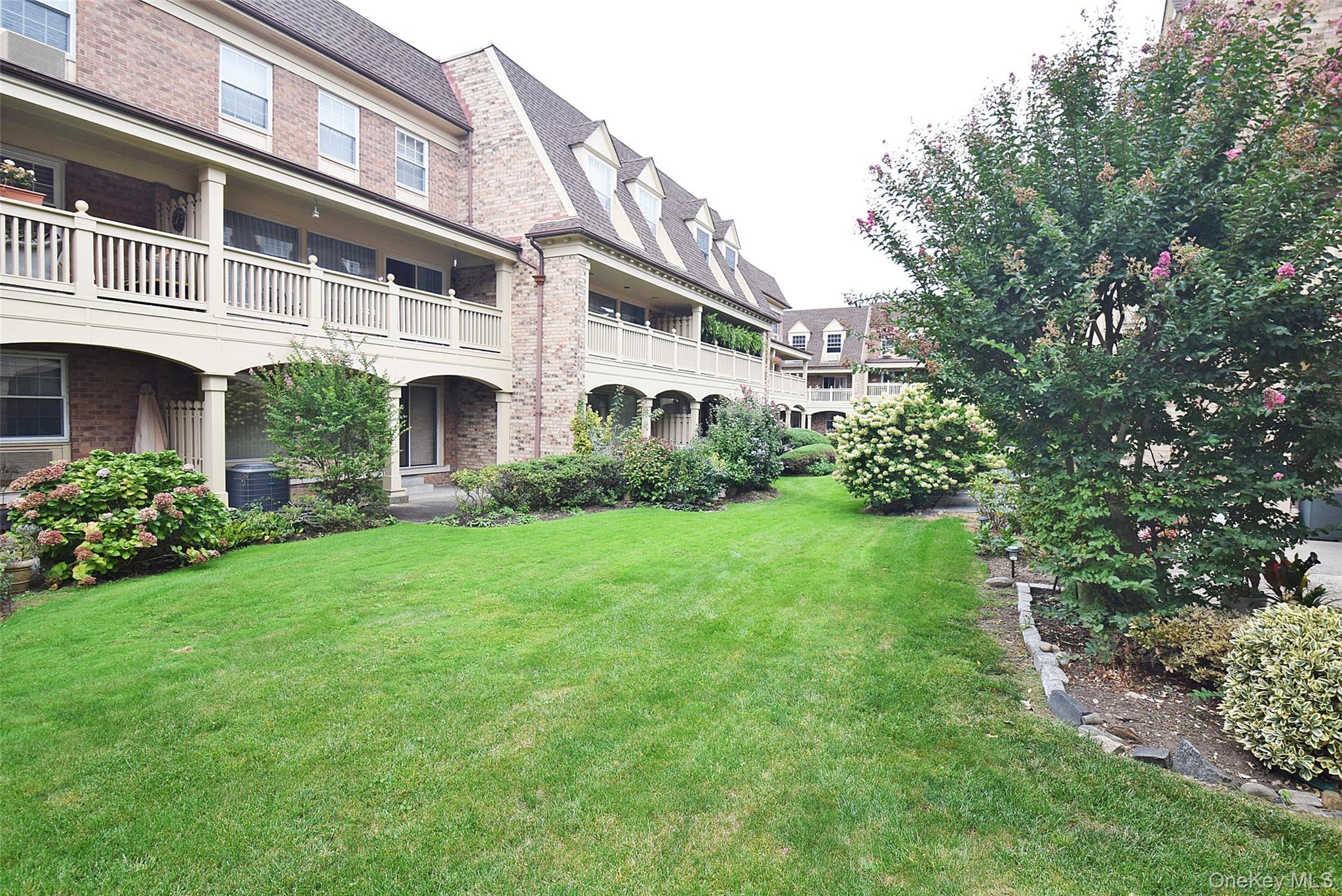 12-36 Estates Lane, Unit 49L Queens, NY 11360 - Photo 32 of 37 a view of an house with backyard and garden