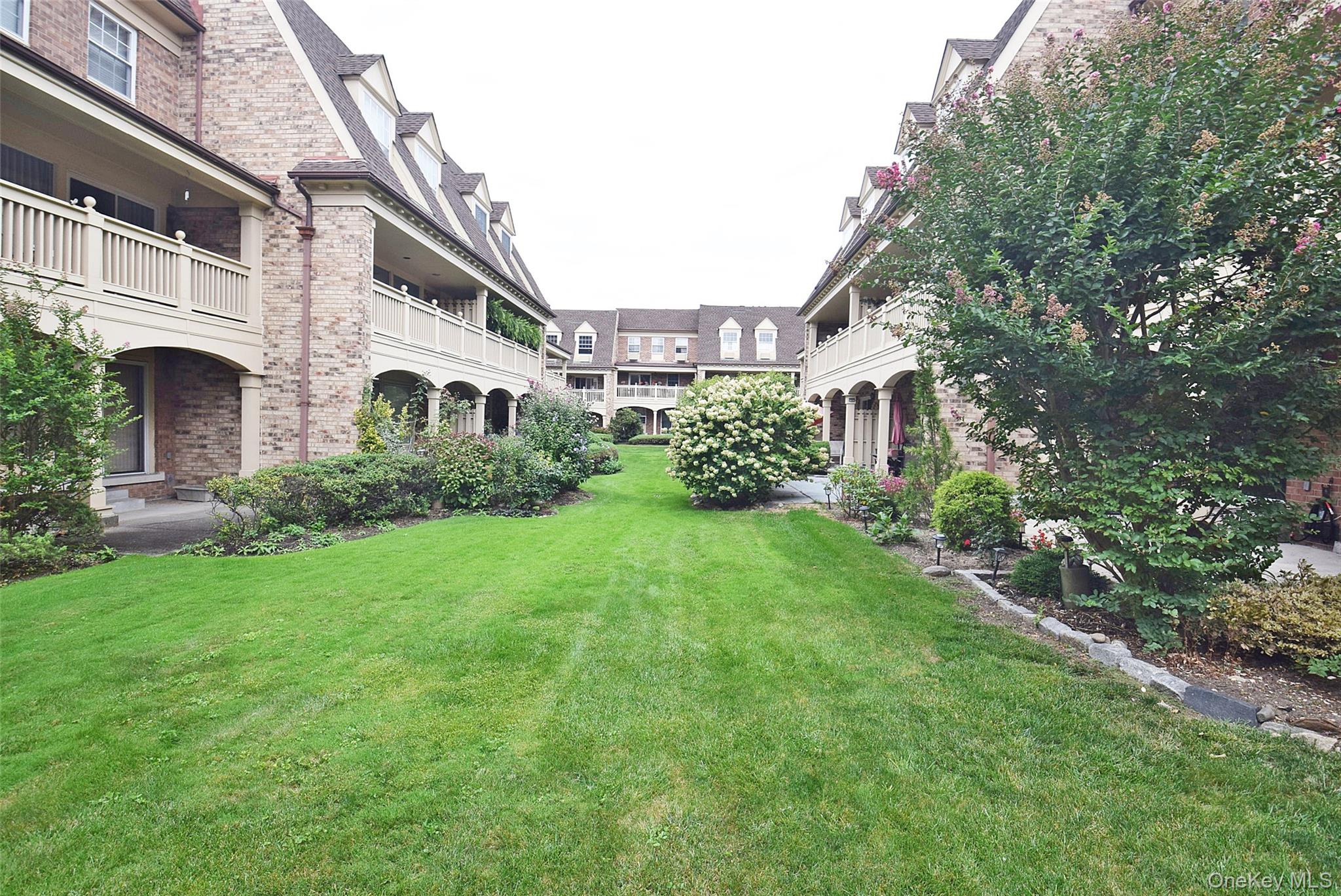 12-36 Estates Lane, Unit 49L Queens, NY 11360 - Photo 33 of 37 a front view of a house with garden