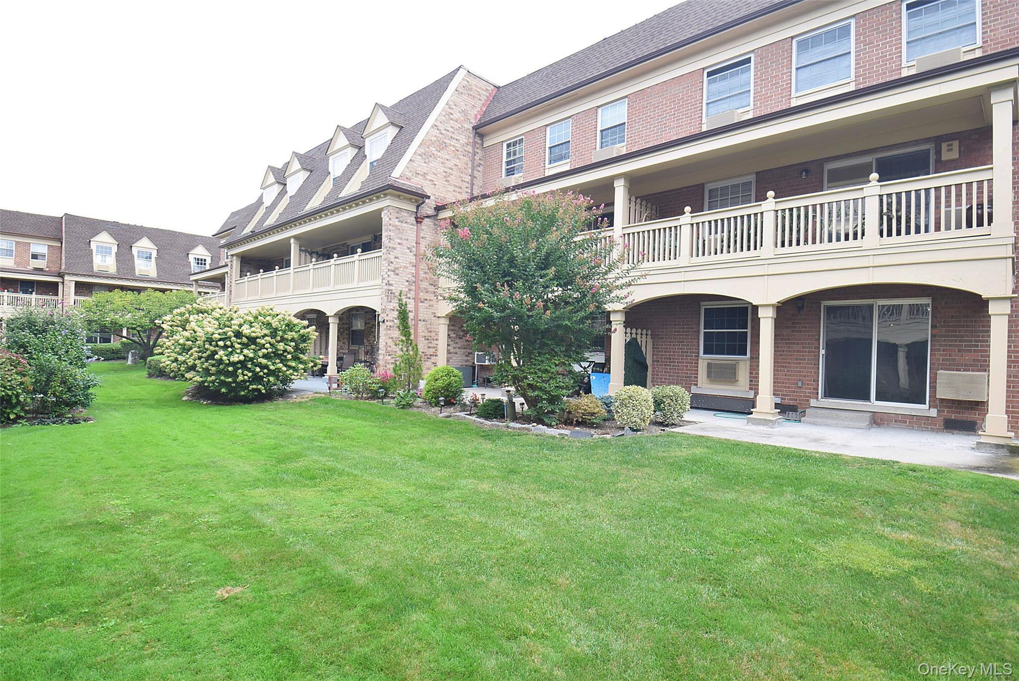 12-36 Estates Lane, Unit 49L Queens, NY 11360 - Photo 34 of 37 front view of a building with a yard