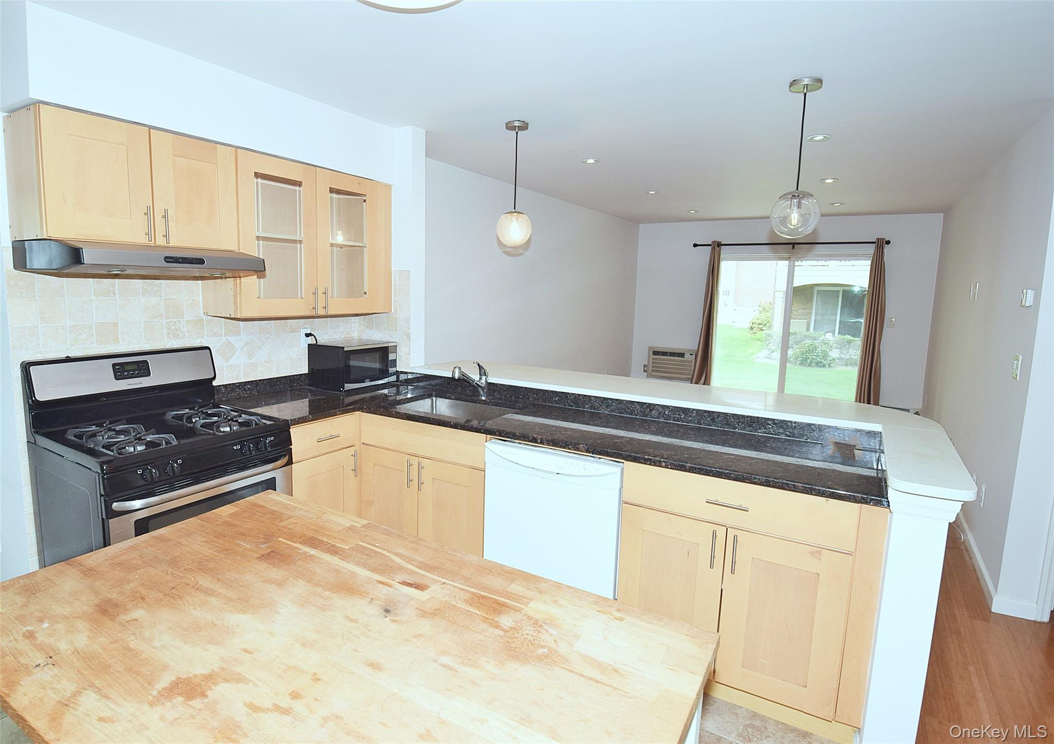 12-36 Estates Lane, Unit 49L Queens, NY 11360 - Photo 6 of 37 a kitchen with granite countertop a stove a sink and a refrigerator